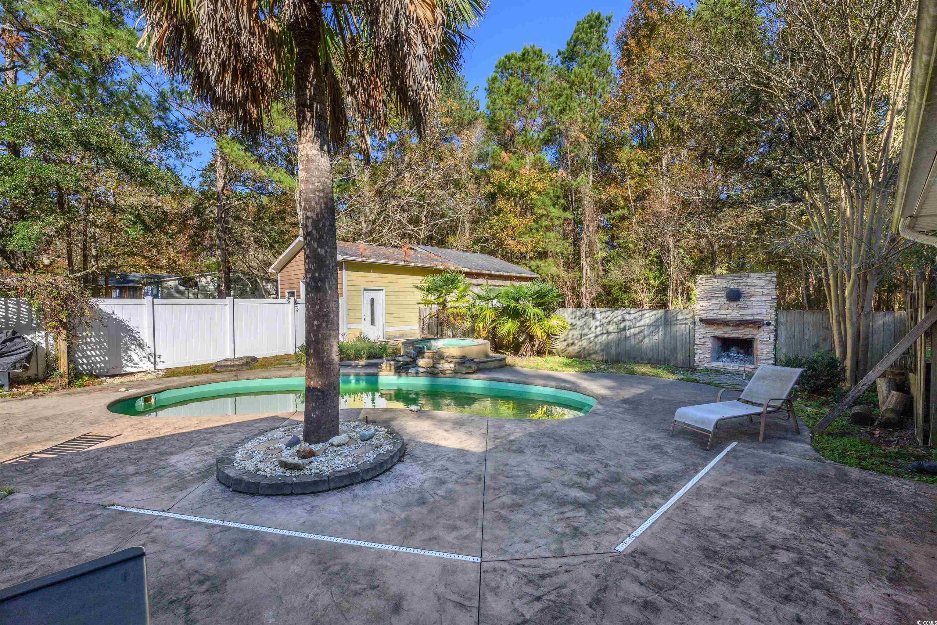 6252 Salem Road Myrtle Beach, SC 29588 - Photo 16 of 39 View of swimming pool with a patio area, an outbuilding, and an outdoor stone fireplace