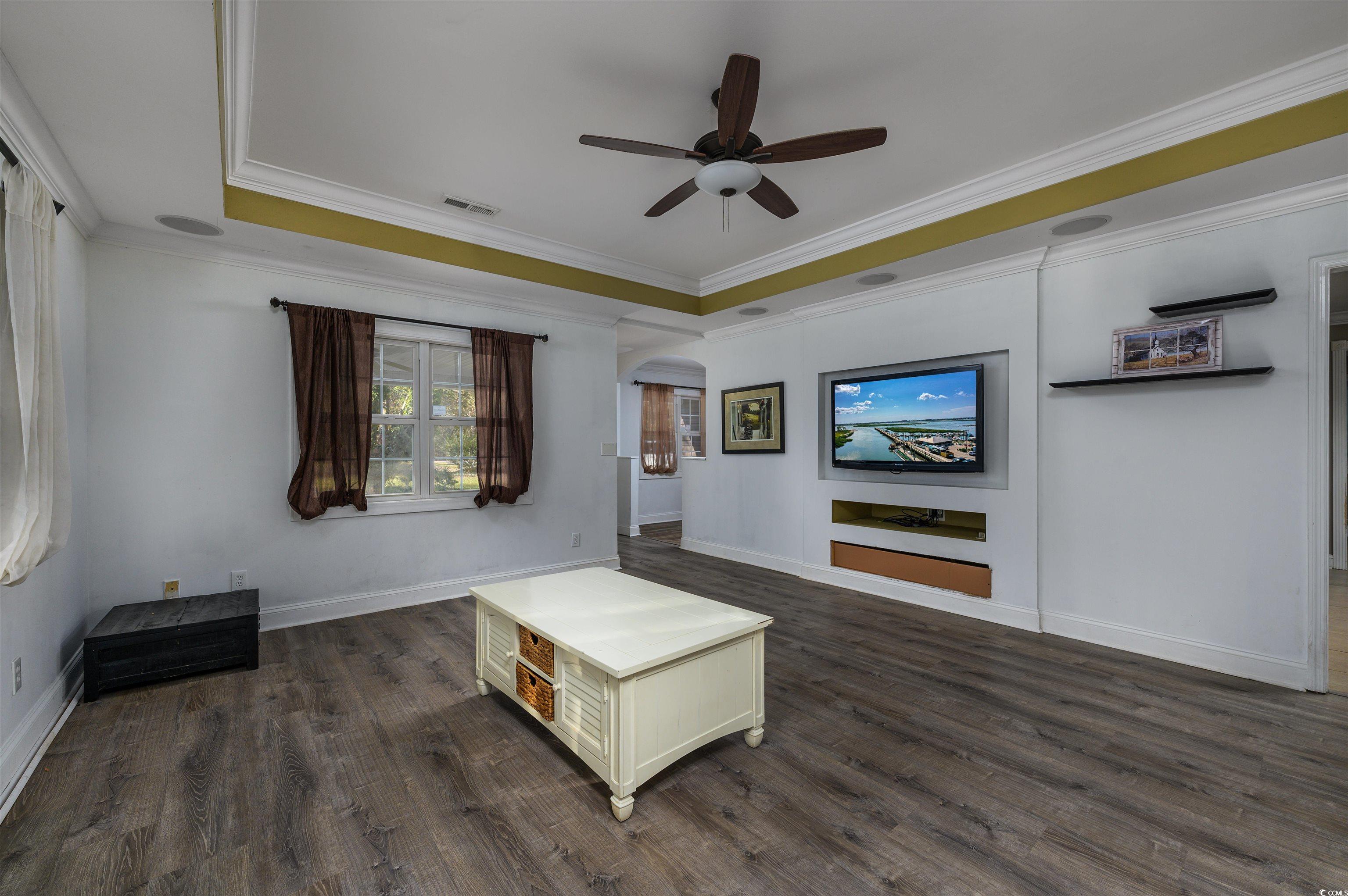 6252 Salem Road Myrtle Beach, SC 29588 - Photo 25 of 39 Living room featuring a raised ceiling, crown molding, ceiling fan, and dark hardwood / wood-style floors