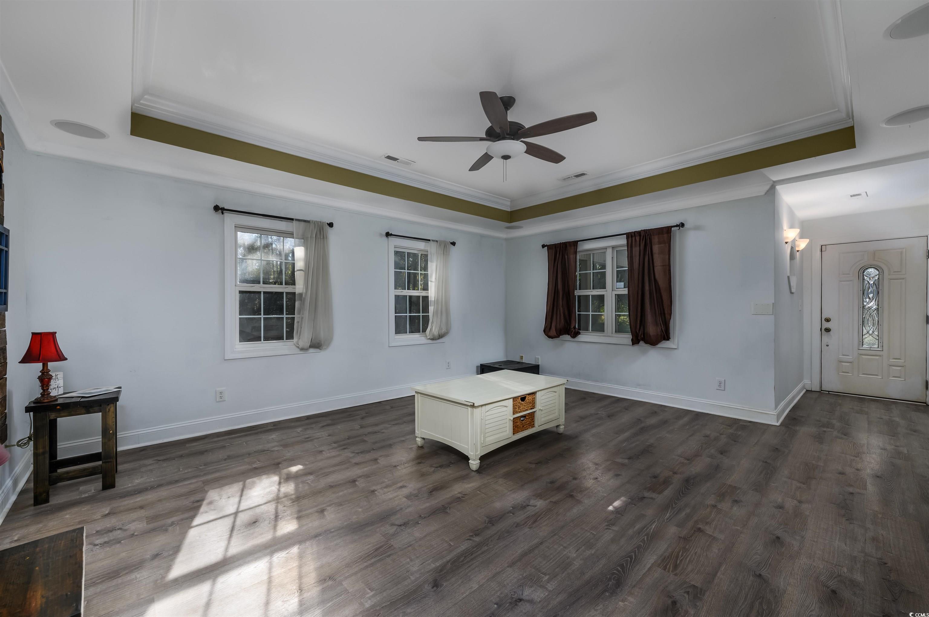 6252 Salem Road Myrtle Beach, SC 29588 - Photo 26 of 39 Living room with a tray ceiling, ceiling fan, crown molding, and dark hardwood / wood-style floors