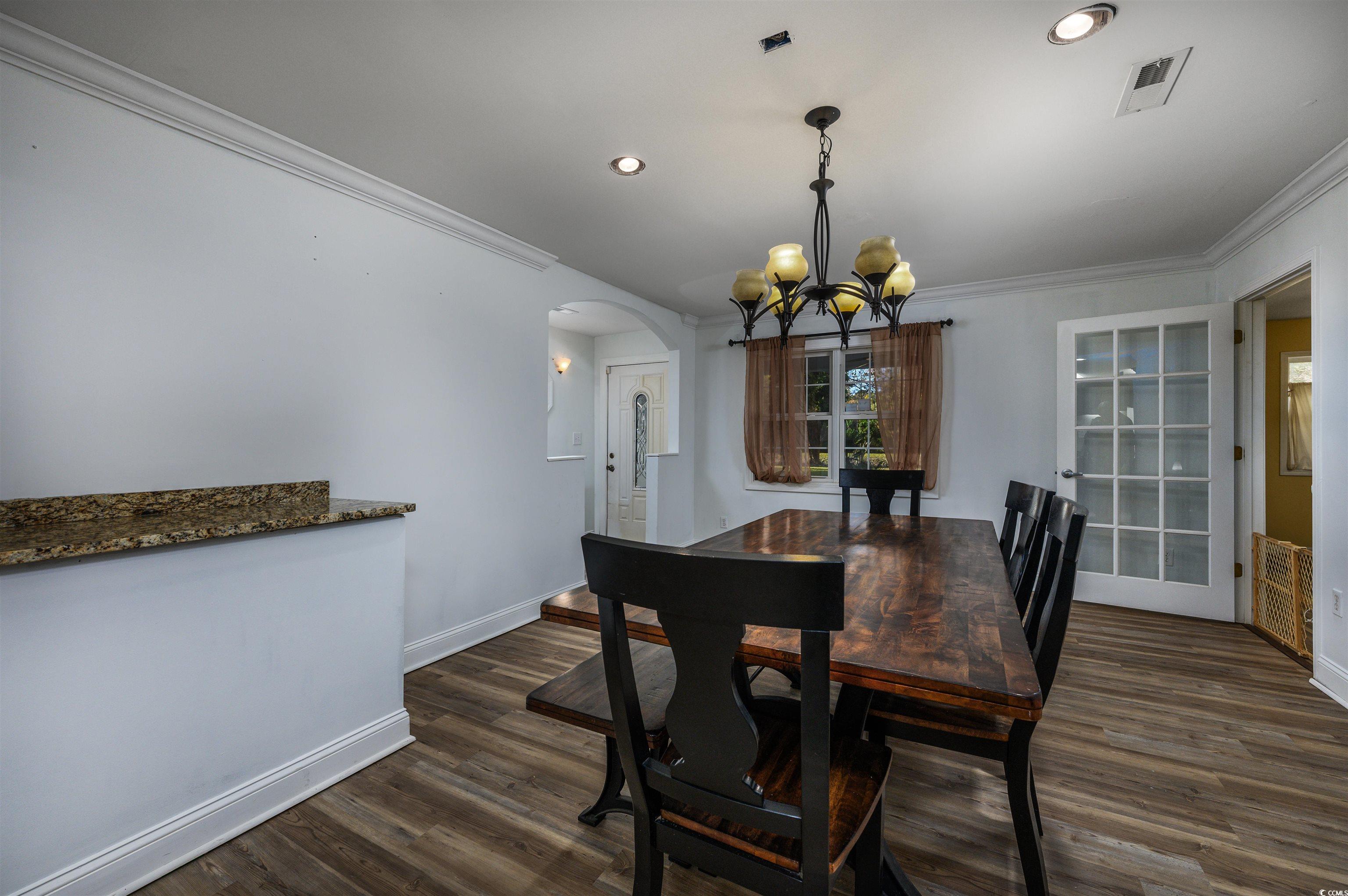 6252 Salem Road Myrtle Beach, SC 29588 - Photo 27 of 39 Dining space with a notable chandelier, dark hardwood / wood-style floors, and ornamental molding