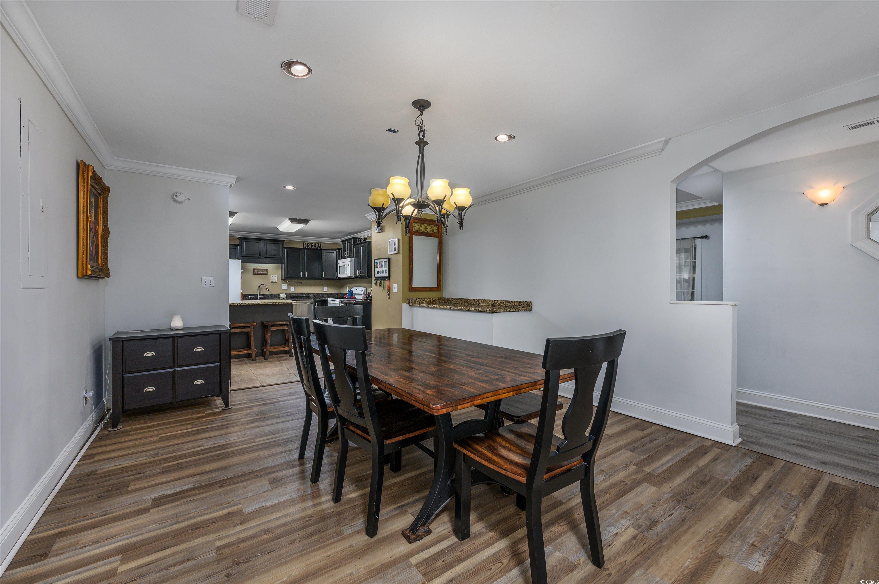 6252 Salem Road Myrtle Beach, SC 29588 - Photo 28 of 39 Dining space featuring crown molding, sink, a chandelier, and dark hardwood / wood-style floors