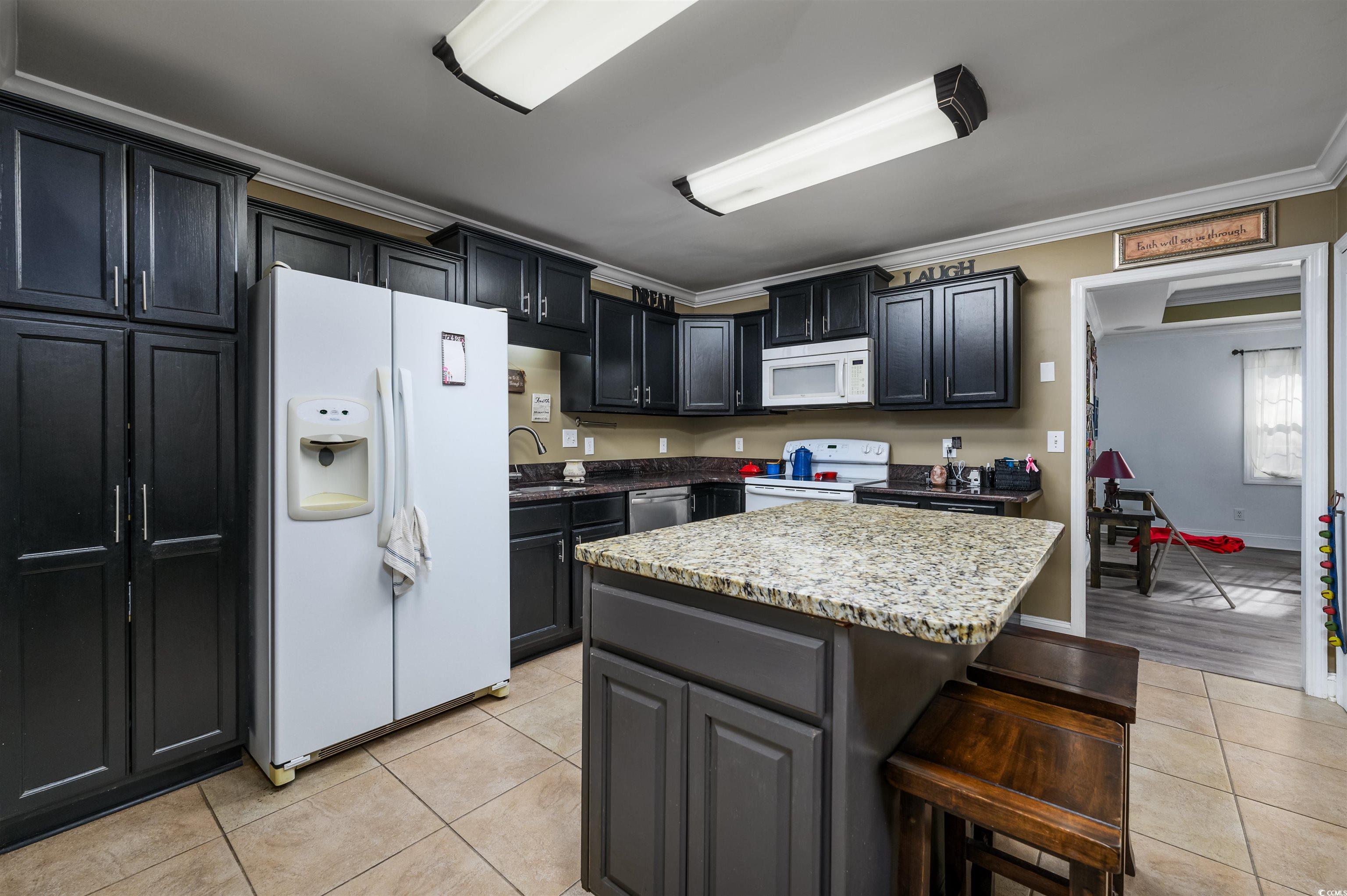 6252 Salem Road Myrtle Beach, SC 29588 - Photo 30 of 39 Kitchen featuring white appliances, crown molding, sink, a kitchen island, and light tile patterned flooring
