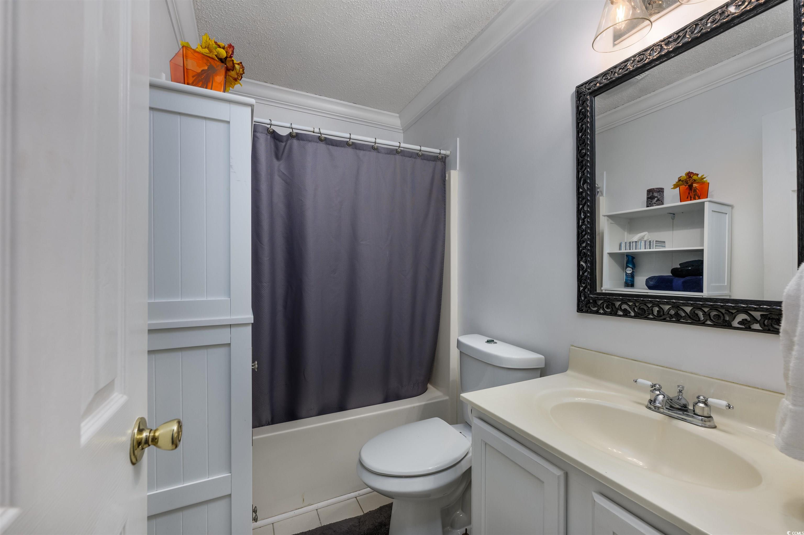 6252 Salem Road Myrtle Beach, SC 29588 - Photo 34 of 39 Full bathroom with vanity, toilet, shower / bathtub combination with curtain, ornamental molding, and a textured ceiling