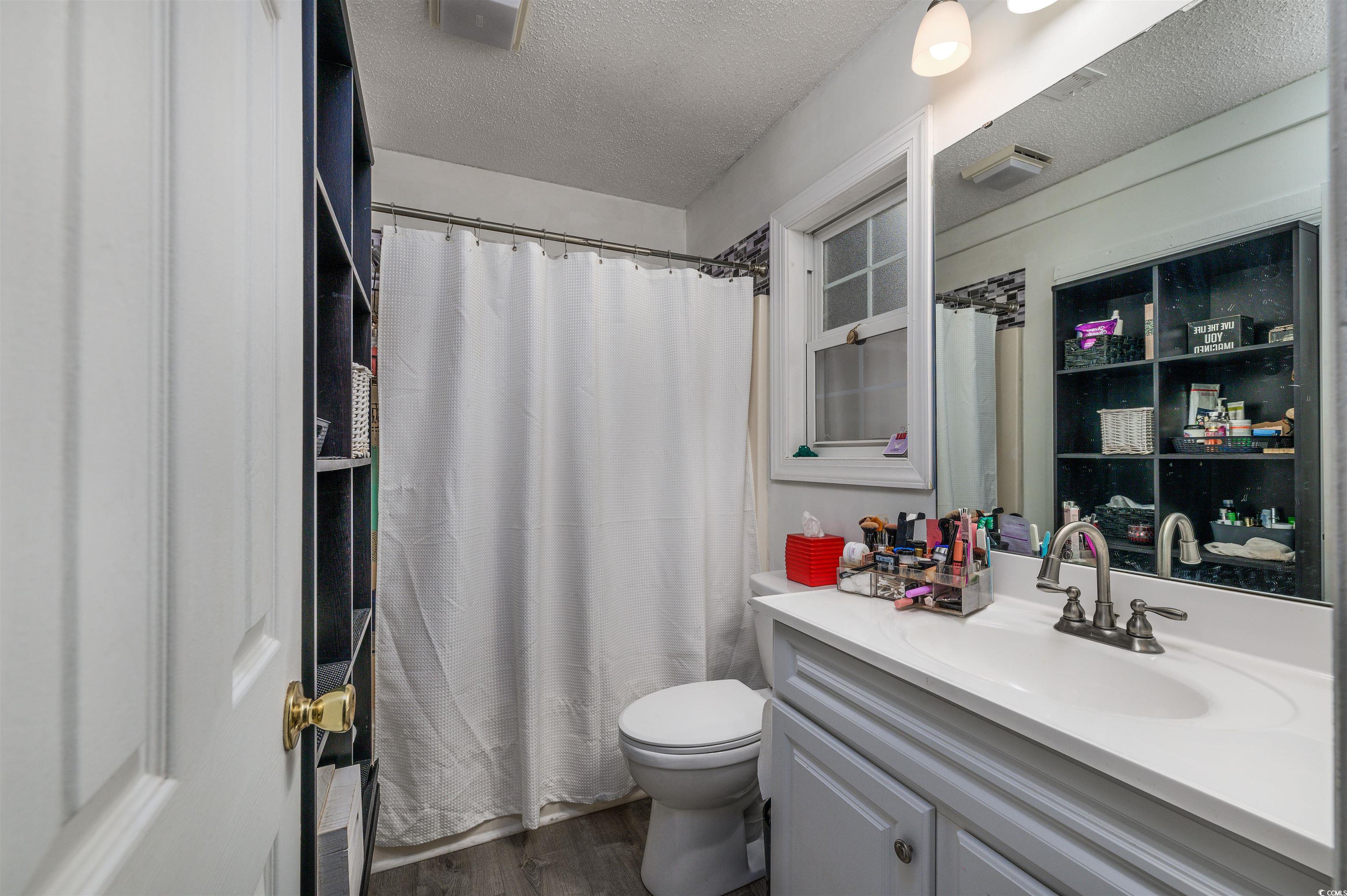 6252 Salem Road Myrtle Beach, SC 29588 - Photo 37 of 39 Bathroom featuring walk in shower, vanity, a textured ceiling, hardwood / wood-style floors, and toilet