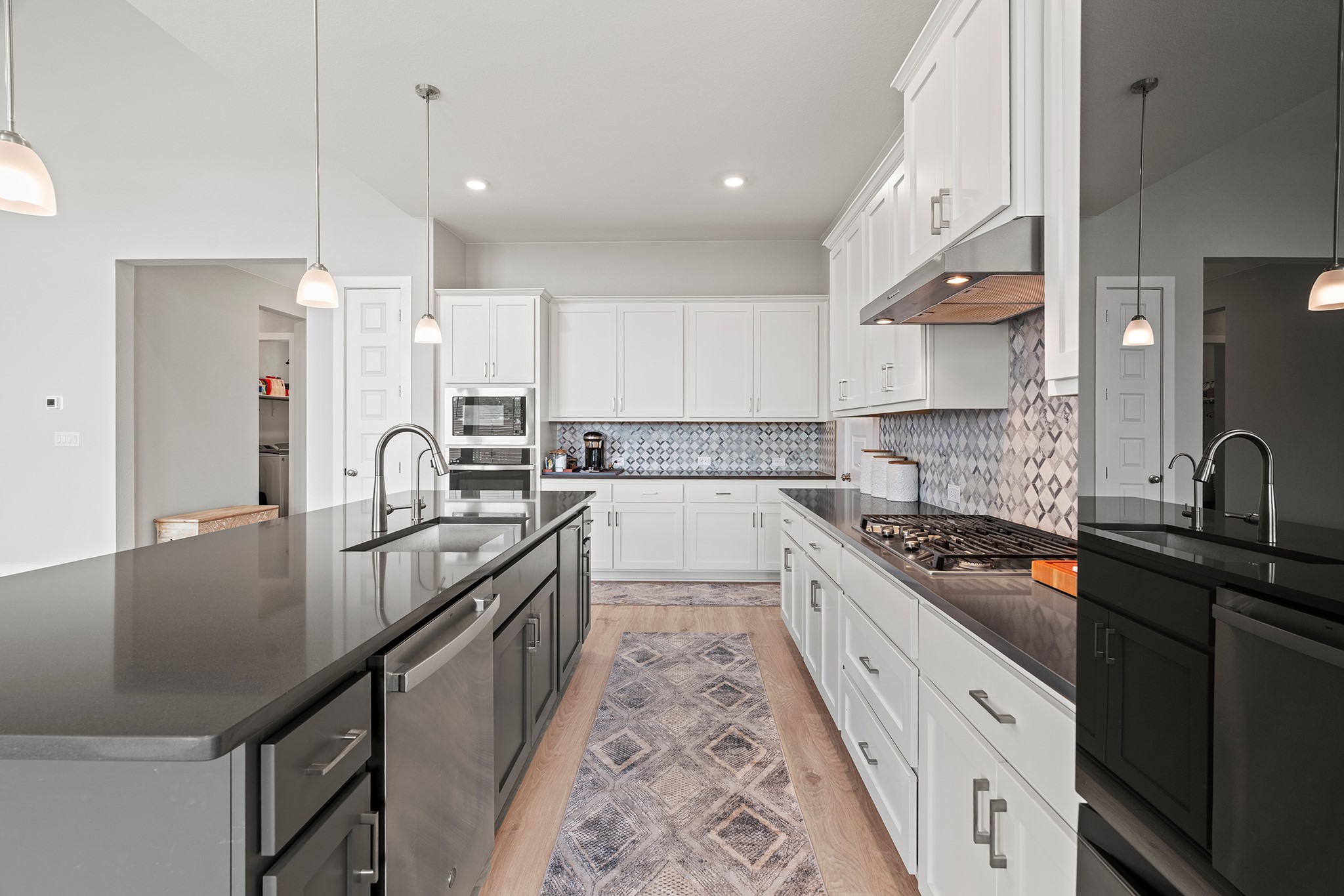 2112 Tobiano Trace Georgetown, TX 78633 - Photo 9 of 40 Kitchen with hanging light fixtures, white cabinetry, decorative backsplash, an island with sink, and stainless steel appliances