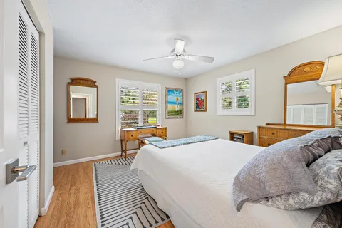 a bedroom with a large bed wooden floor and window