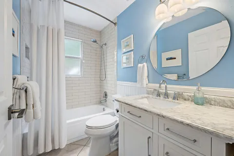 a bathroom with a granite countertop sink mirror vanity and toilet