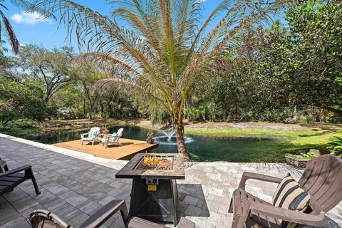 a view of a patio with table and chairs and a barbeque