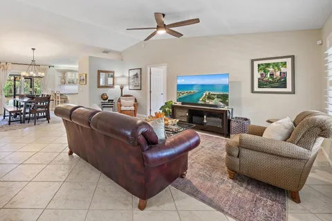 a living room with furniture a ceiling fan and a rug