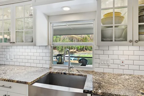 a kitchen with a sink and a stove top oven