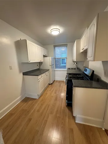 a kitchen with a sink a stove and cabinets