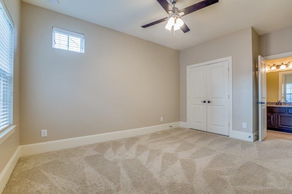 46 East Rafters Row The Woodlands, TX 77380 - Photo 17 of 25 Generously sized secondary bedroom with ceiling fan, large windows, and plush carpeting.