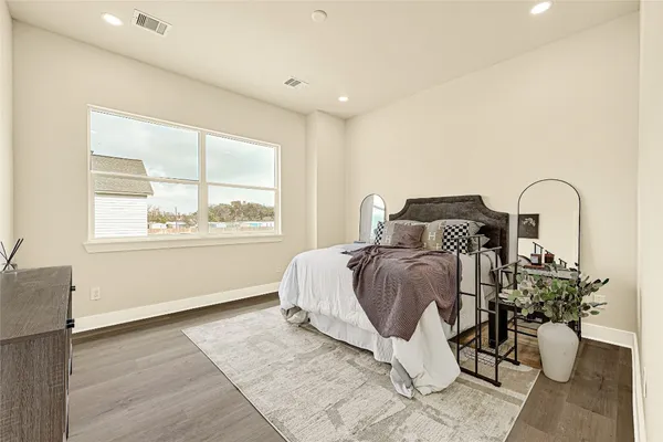 a bedroom with a bed and a large window
