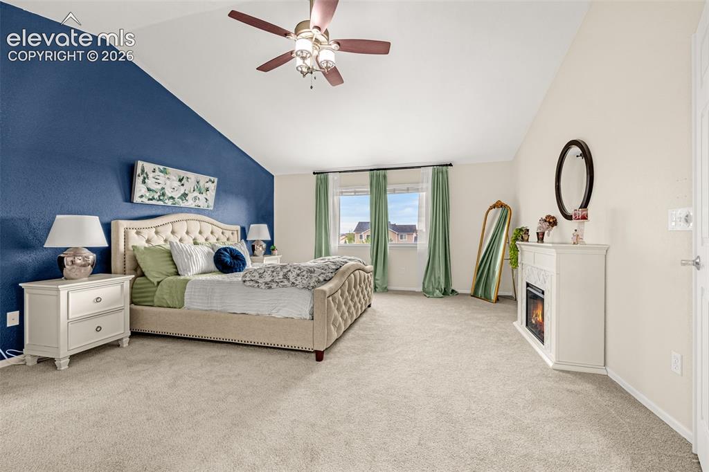 9127 Oakmont Road Peyton, CO 80831 - Photo 18 of 49 a spacious bedroom with a bed and a chandelier