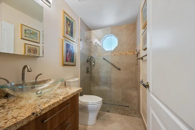 a bathroom with a granite countertop sink toilet and shower