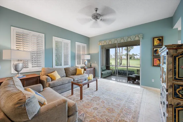 a living room with furniture a flat screen tv and a large window