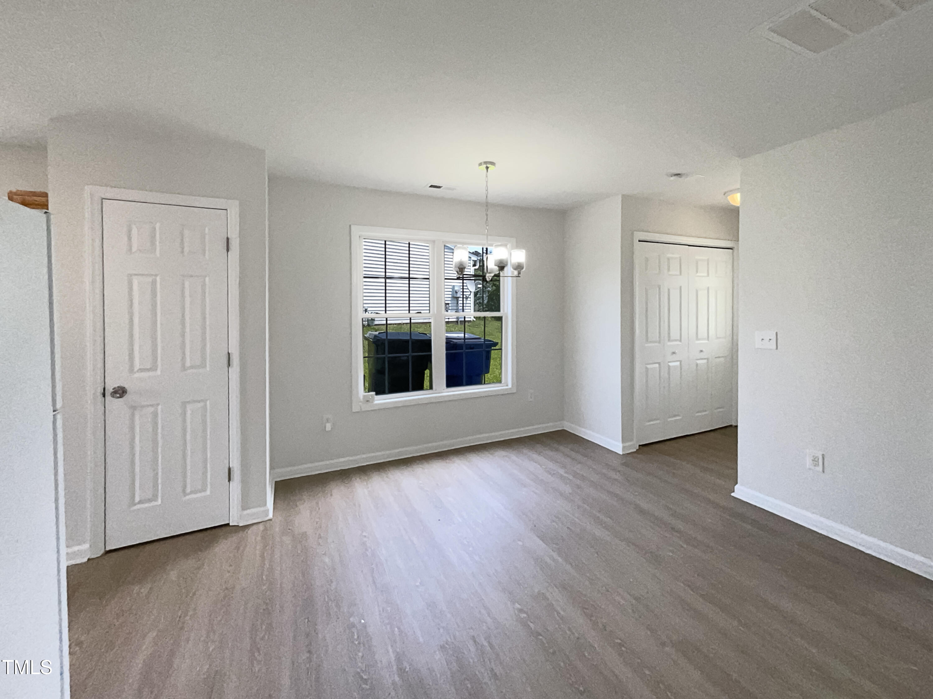 4025 Scofield Drive Raleigh, NC 27610 - Photo 11 of 18 an empty room with wooden floor and windows