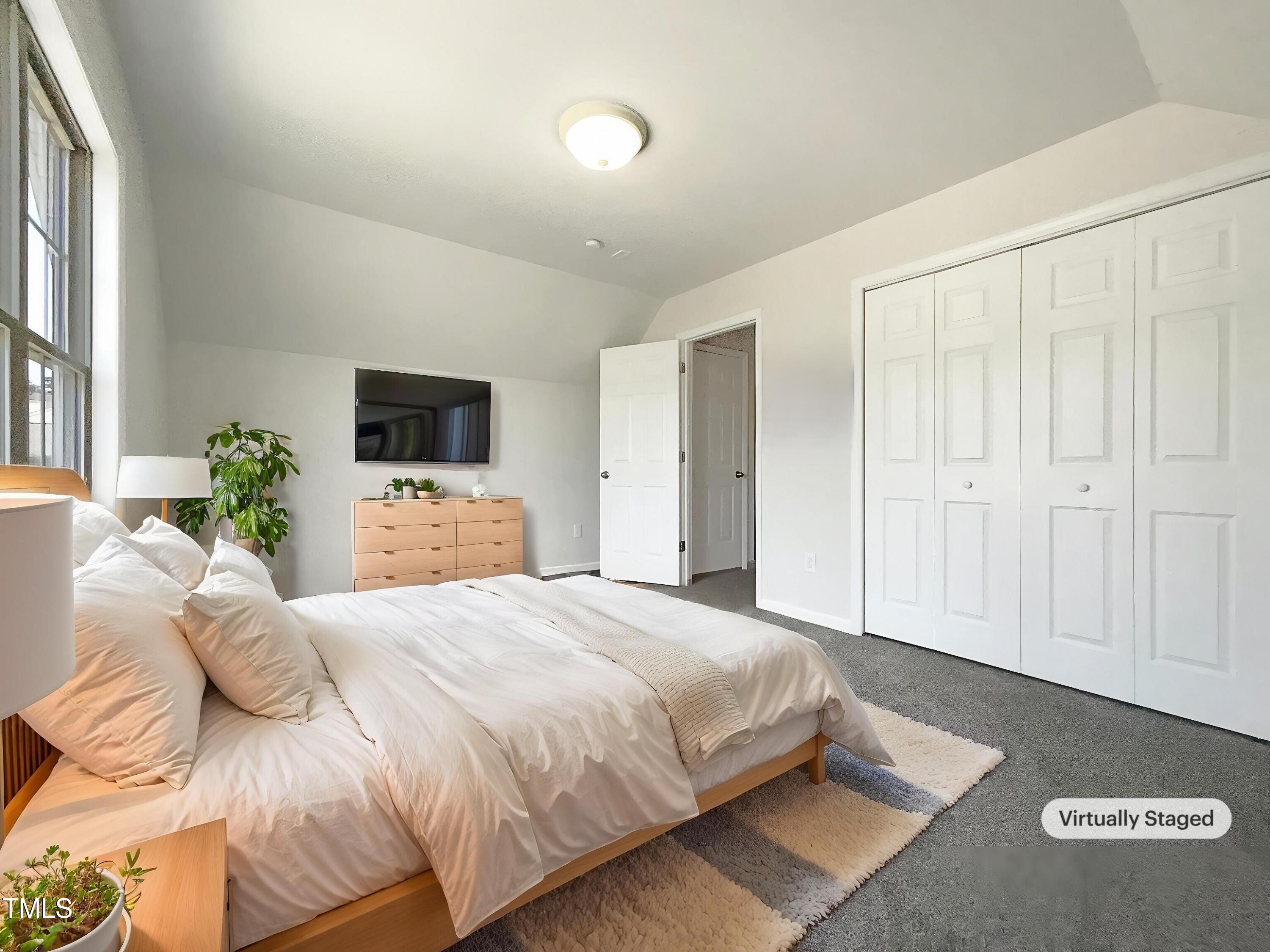 4025 Scofield Drive Raleigh, NC 27610 - Photo 4 of 18 a bedroom with a bed potted plant and a window