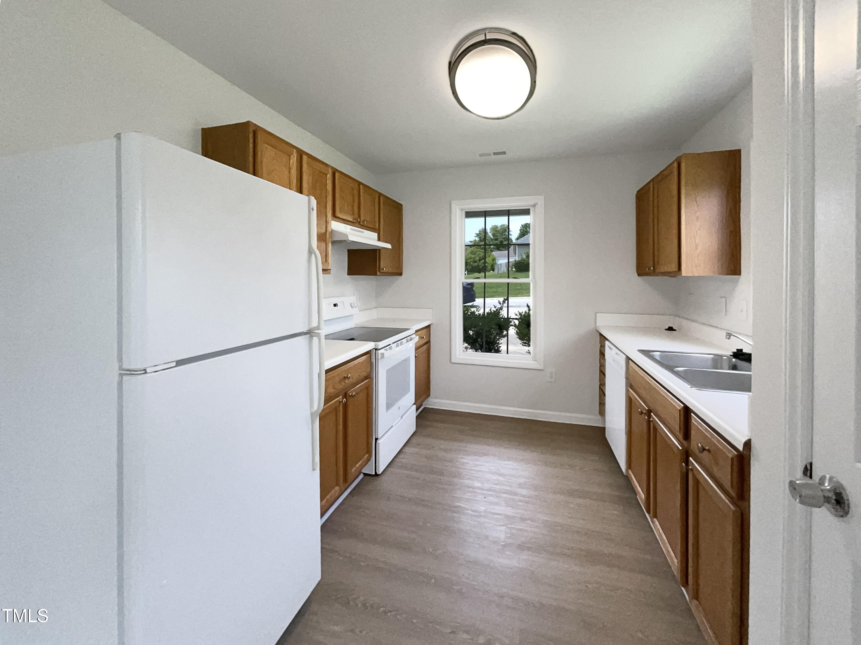 4025 Scofield Drive Raleigh, NC 27610 - Photo 6 of 18 a kitchen with sink a refrigerator and a stove