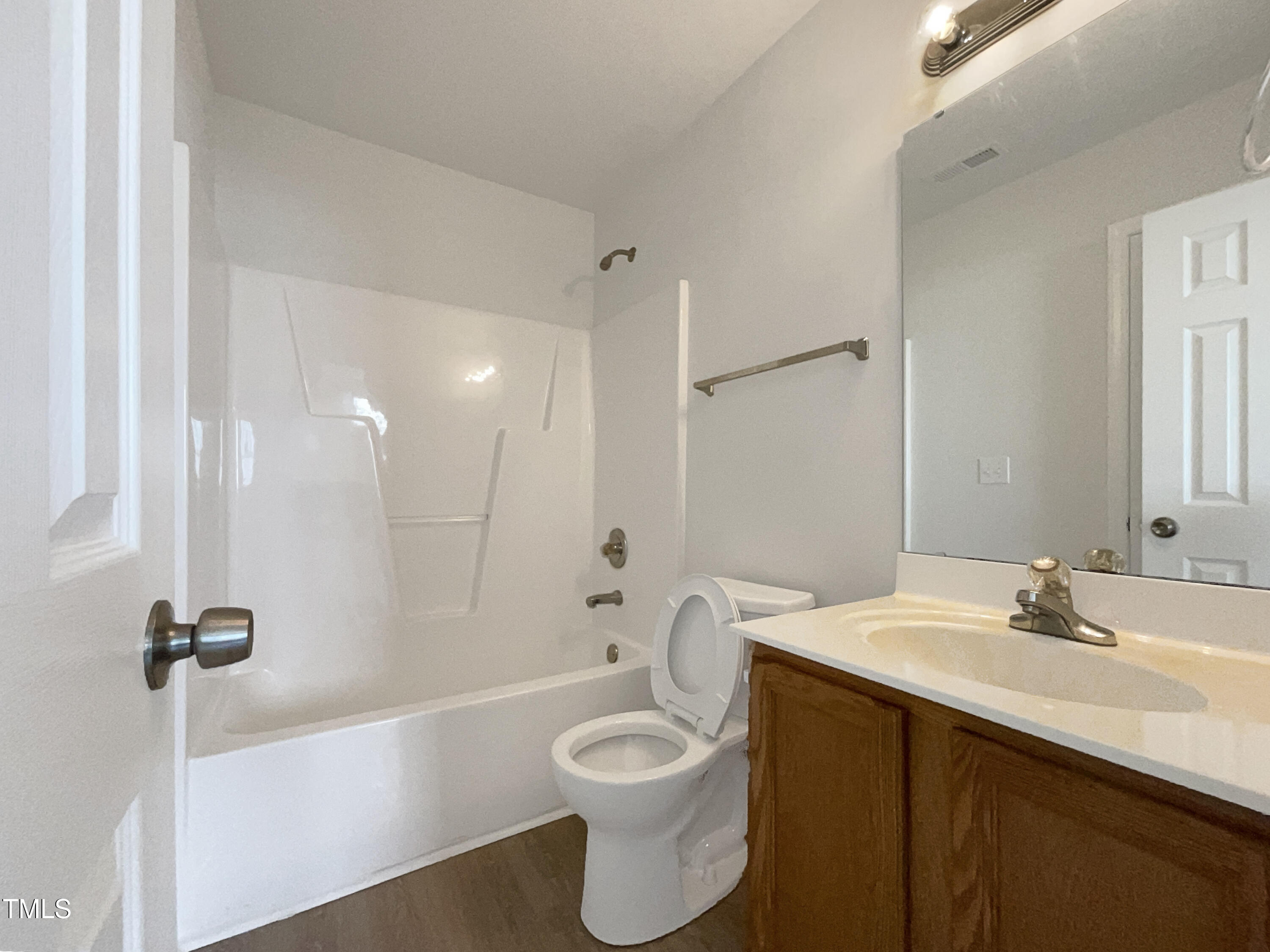 4025 Scofield Drive Raleigh, NC 27610 - Photo 7 of 18 a bathroom with a sink a toilet a mirror and bathtub