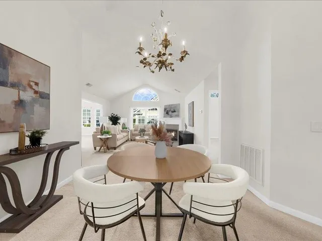 a view of a dining room with furniture and chandelier