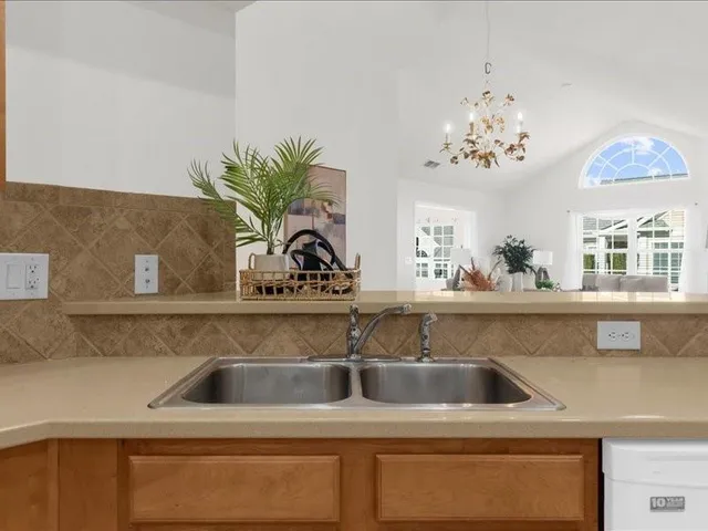 a view of a sink a counter top with cabinets