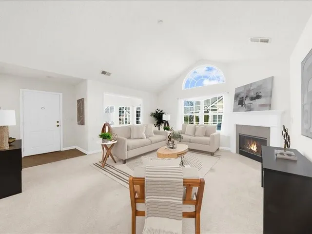 a living room with furniture a fireplace and a large window