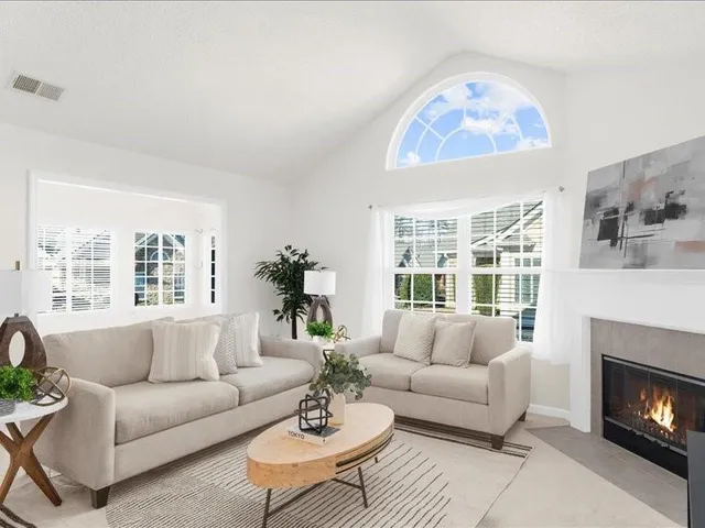 a living room with furniture fireplace and a large window