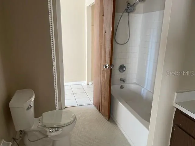 a bathroom with a granite countertop toilet and a bathtub