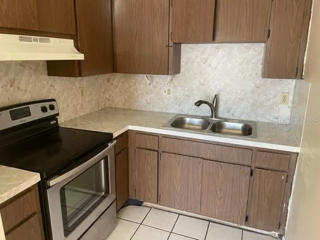 a kitchen with sink cabinets and stove