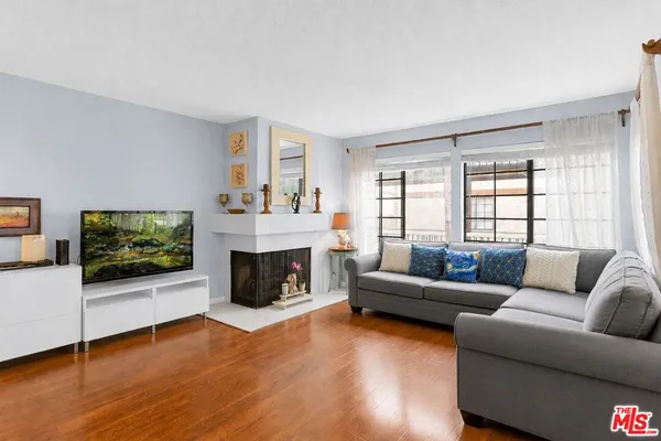 a living room with furniture a flat screen tv and a fireplace