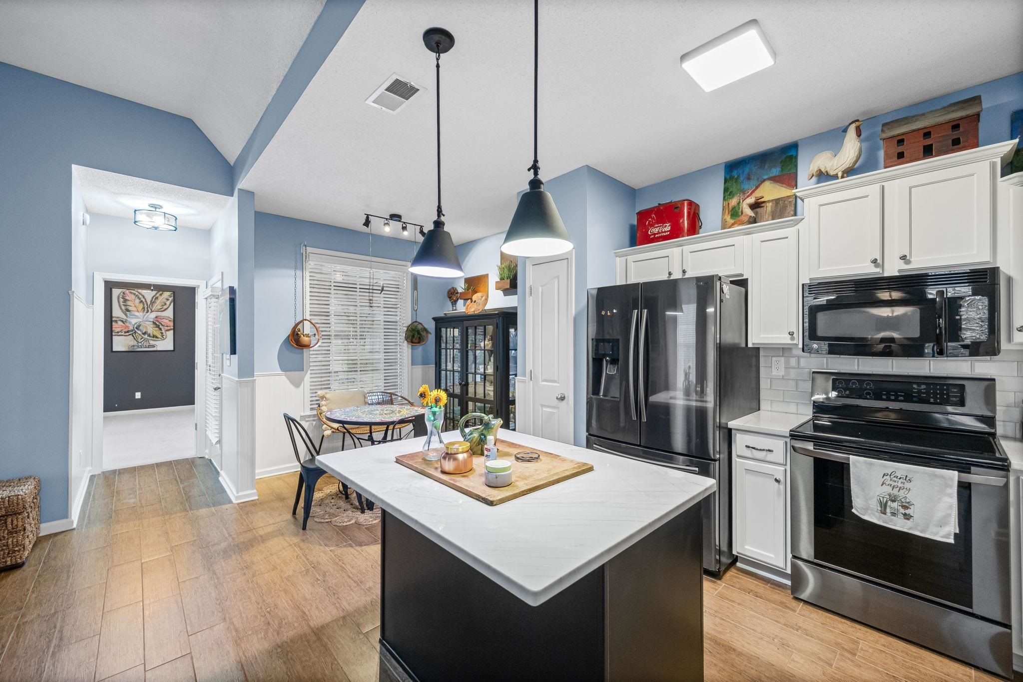 4950 Shaws Ridge Trail Arlington, TN 38002 - Photo 2 of 27 a kitchen that has a kitchen island a stove a microwave and a dining table