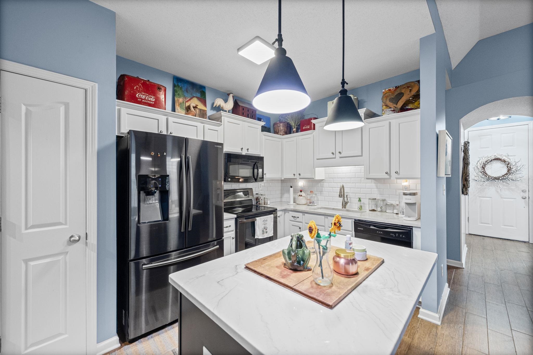 4950 Shaws Ridge Trail Arlington, TN 38002 - Photo 4 of 27 a living room with stainless steel appliances kitchen island a table and chairs