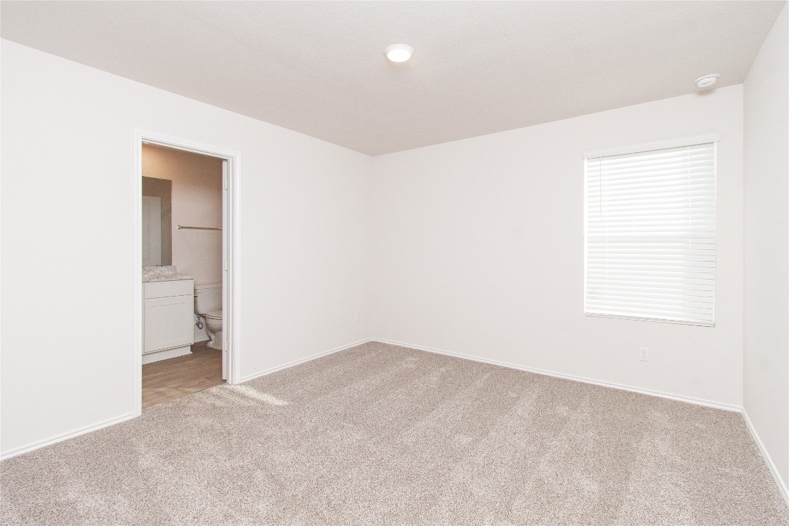 201 Varner Way Lockhart, TX 78644 - Photo 5 of 16 Unfurnished bedroom with light carpet and ensuite bath