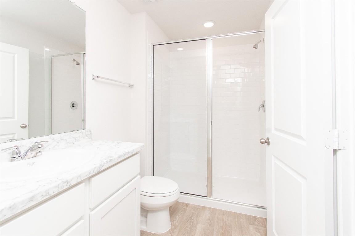 201 Varner Way Lockhart, TX 78644 - Photo 8 of 16 Full bathroom featuring a stall shower, vanity, light wood-style flooring, and recessed lighting