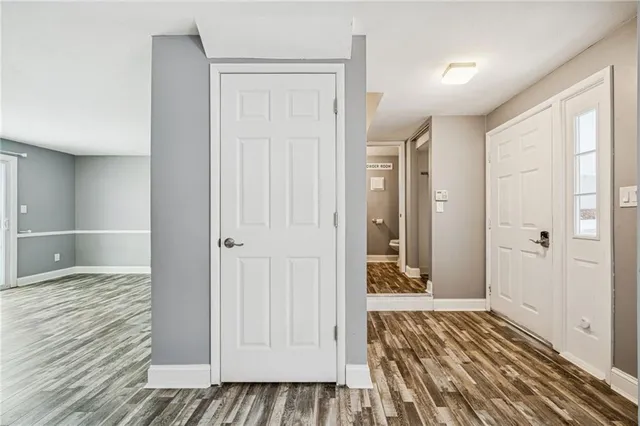 a view of a hallway with wooden floor and cabinet