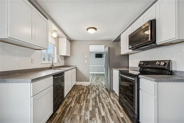 a kitchen with stainless steel appliances a sink dishwasher stove top oven and refrigerator