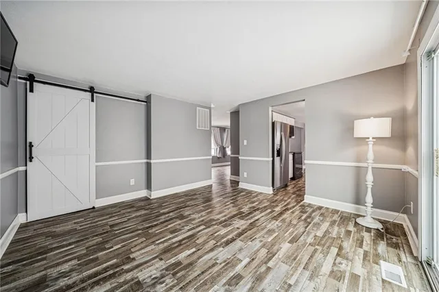 a view of empty room with wooden floor