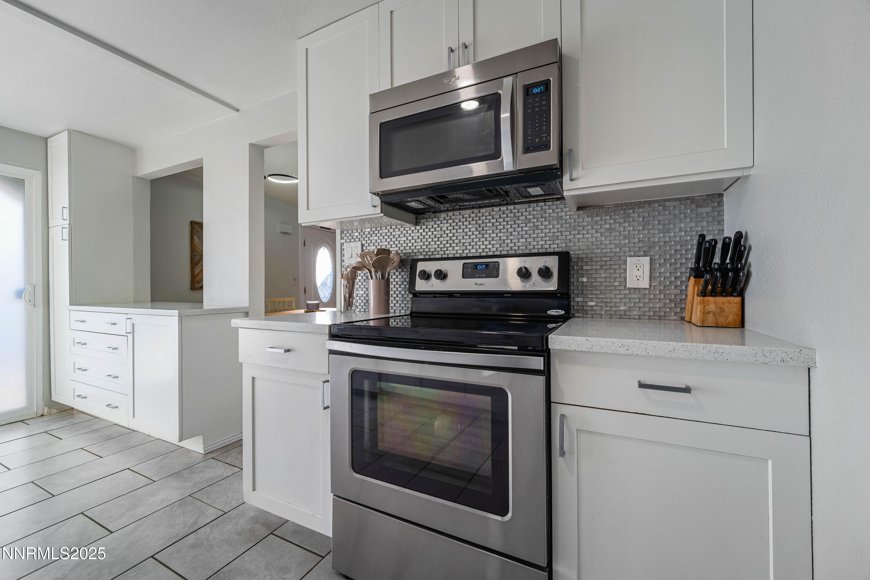 2154 Oppio Street Sparks, NV 89431 - Photo 12 of 21 a kitchen with stainless steel appliances granite countertop grey cabinets a stove a microwave and a sink