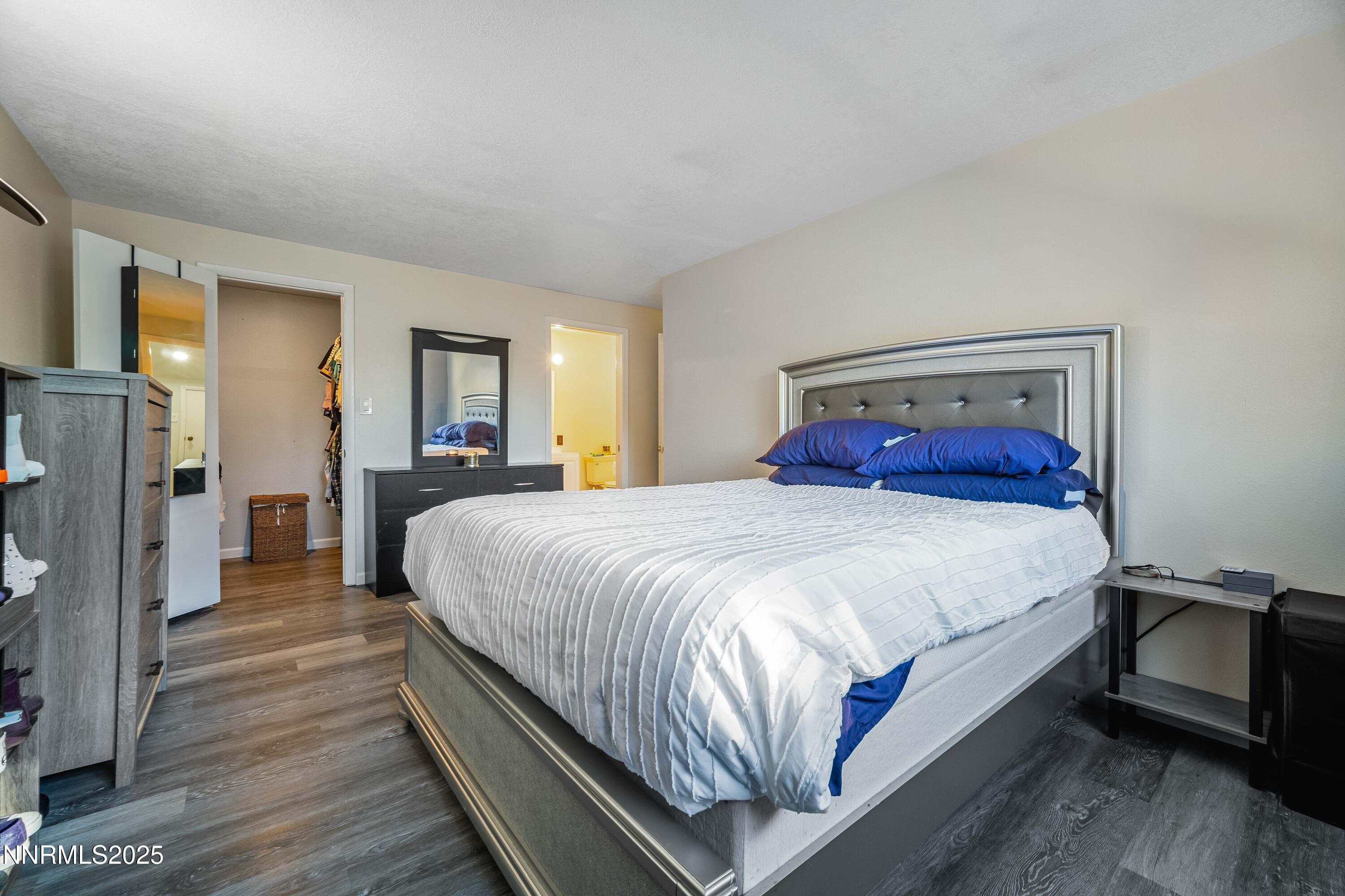 2154 Oppio Street Sparks, NV 89431 - Photo 17 of 21 a large bed sitting in a bedroom next to a window with a flat tv screen and a dresser
