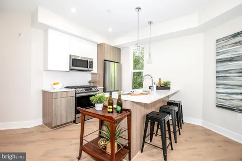 a kitchen with a dining table chairs and refrigerator