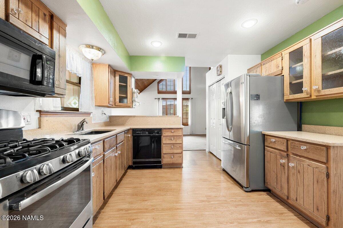 5535 East Western Star Road Flagstaff, AZ 86004 - Photo 10 of 49 a kitchen with stainless steel appliances granite countertop a stove top oven a refrigerator and a sink