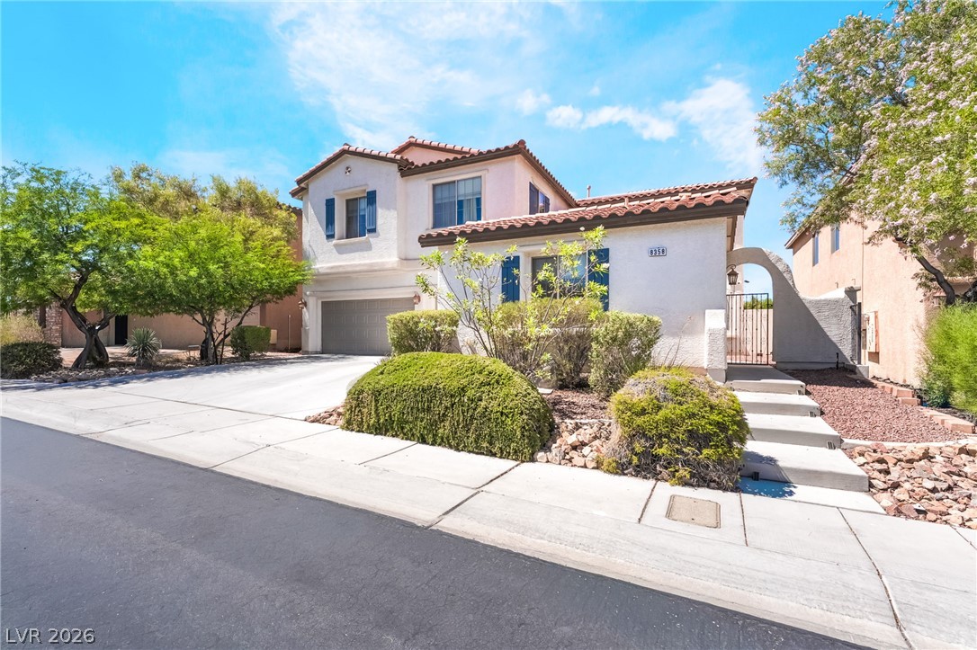 8358 Nelson Ridge Lane Las Vegas, NV 89178 - Photo 3 of 43 A terracotta-tiled roof crowns this residence, featuring a gated walkway and a well-maintained driveway.