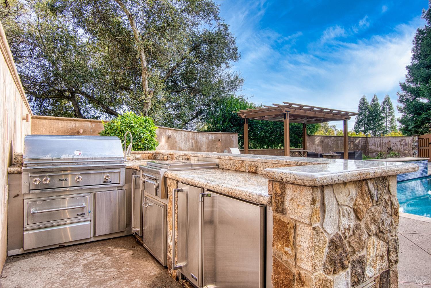 2703 Brush Creek Road Santa Rosa, CA 95404 - Photo 69 of 78 a swimming pool with a table and chairs under an umbrella