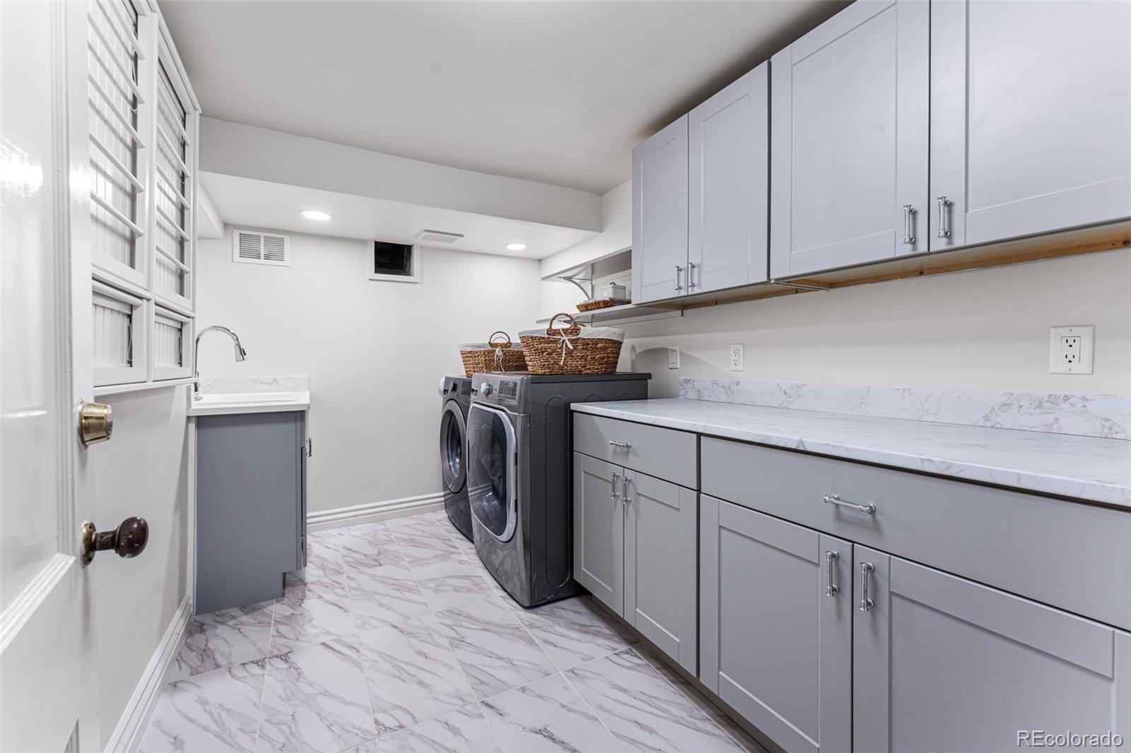 28 Crestmoor Drive Denver, CO 80220 - Photo 39 of 45 a utility room with cabinets washer and dryer