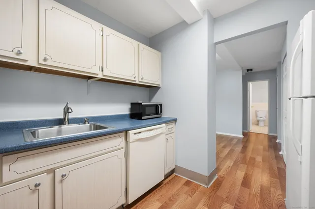 a kitchen with white cabinets and sink