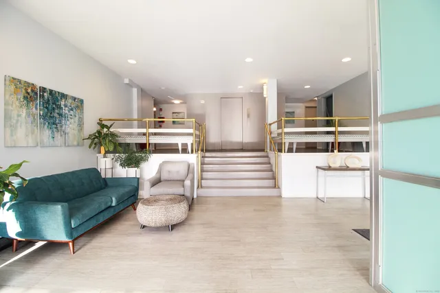 a utility room with stainless steel appliances wooden floor and a view of dining room