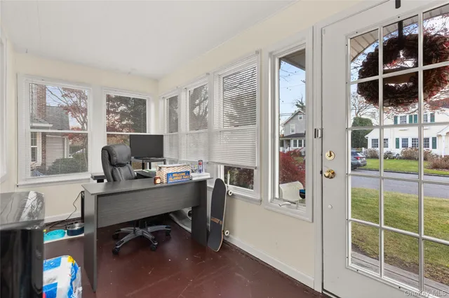 a view of a workspace with furniture and a window