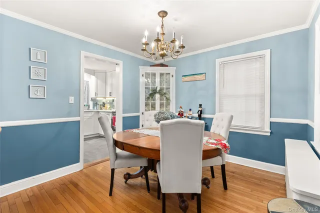 a view of a dining room with furniture a chandelier and wooden floor