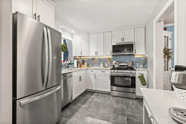 a kitchen with granite countertop a refrigerator stove and microwave